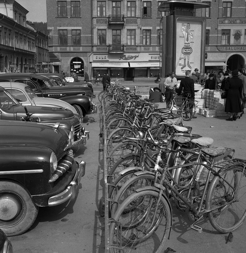 Bilar och cyklar parkerade på Stora Torget utmed Torgatan, år 1953. Fotograf: Norrlandsbild Bildkälla: Sundsvalls museum