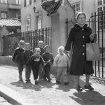 Kvinna på promenad med sex barn sammanhållna med ett snöre