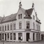 Det nybyggda Malmbergska huset från år 1894. I entrén står en man med förkläde
