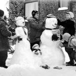 Fyra barn bygger snögubbar