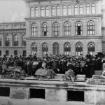 Bilden visar en byggarbetsplats 1925 med påbörjade murar och stor publik.